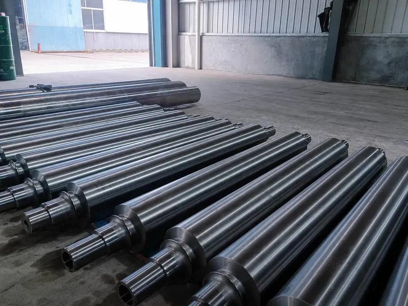 Dark metal drive rollers arranged on a factory floor
