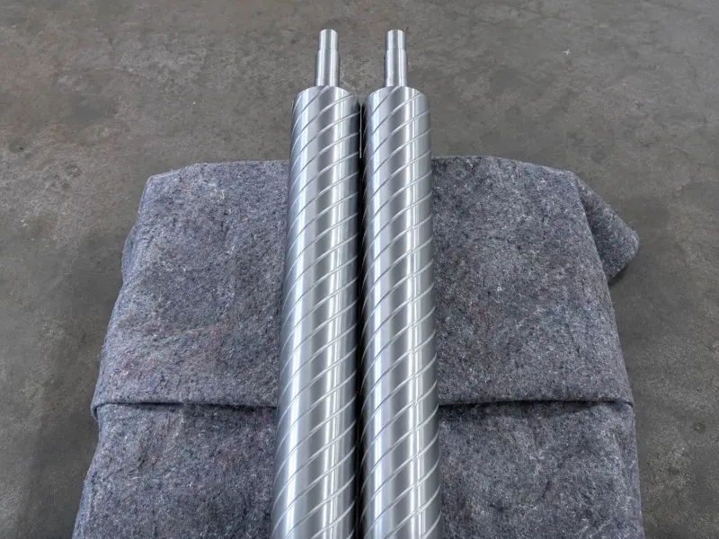 Spiral grooved metal spreader rollers for web handling