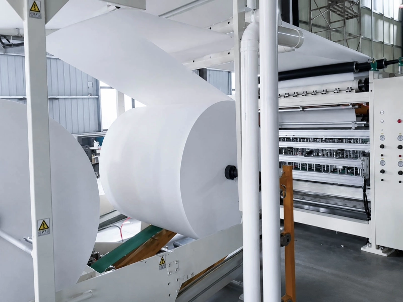 White paper web running through an industrial paper converting line