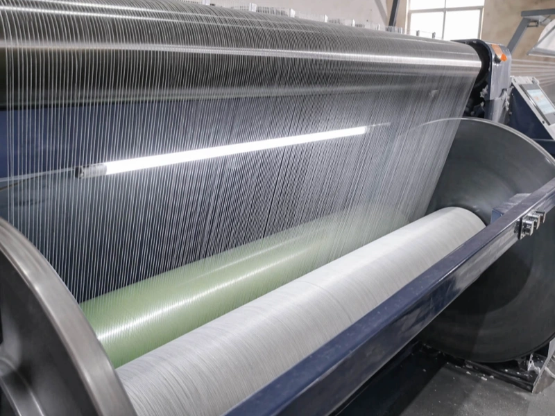 Textile yarn threads running over large industrial rollers